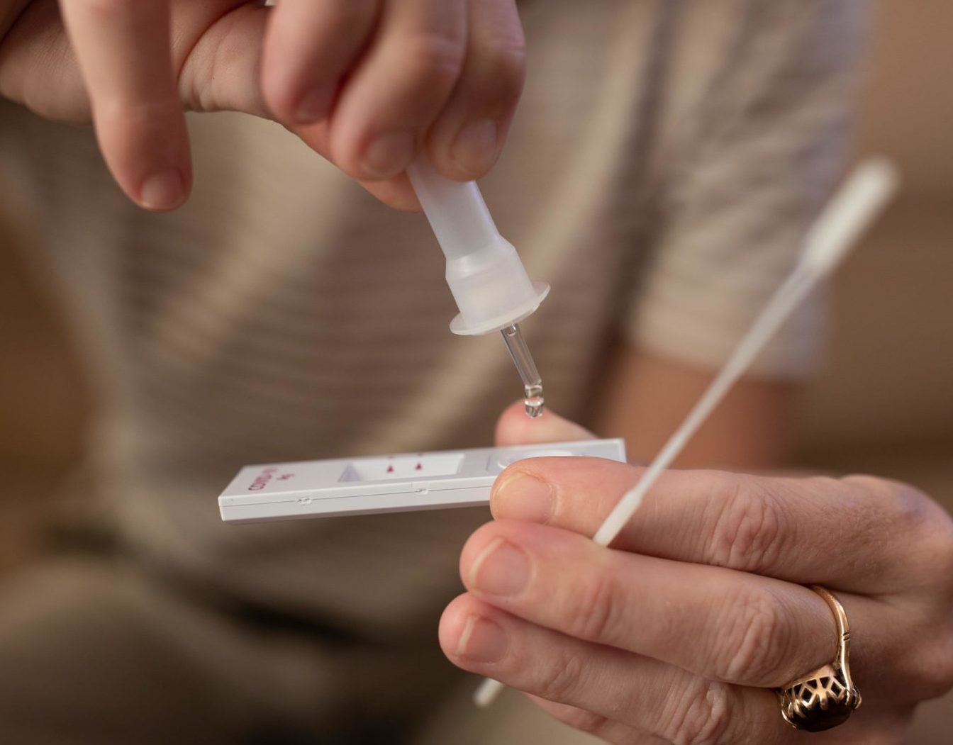 A woman performs a Covid-19 self-test at home.