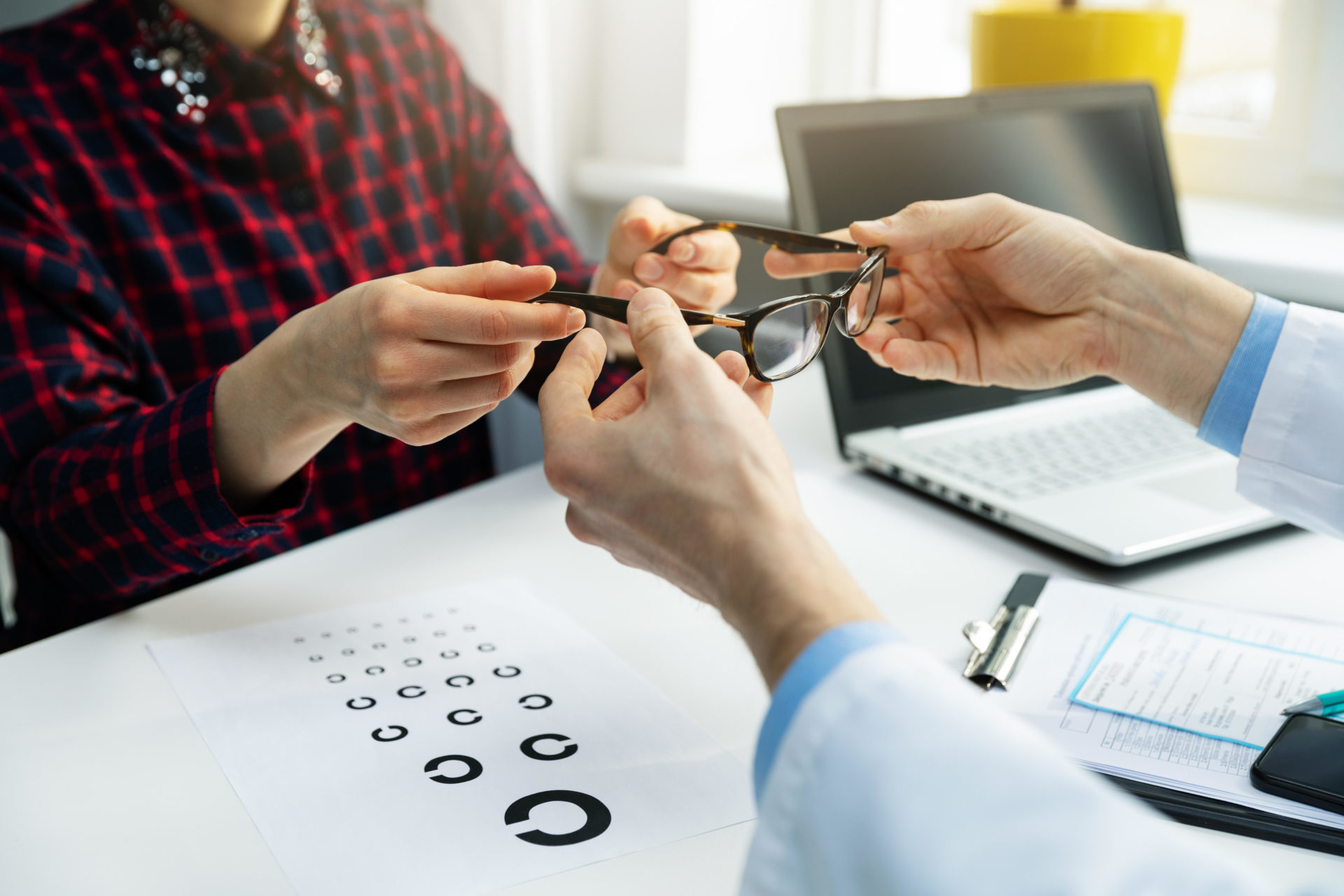 Optometrist visit - woman get her new glasses at optician office.